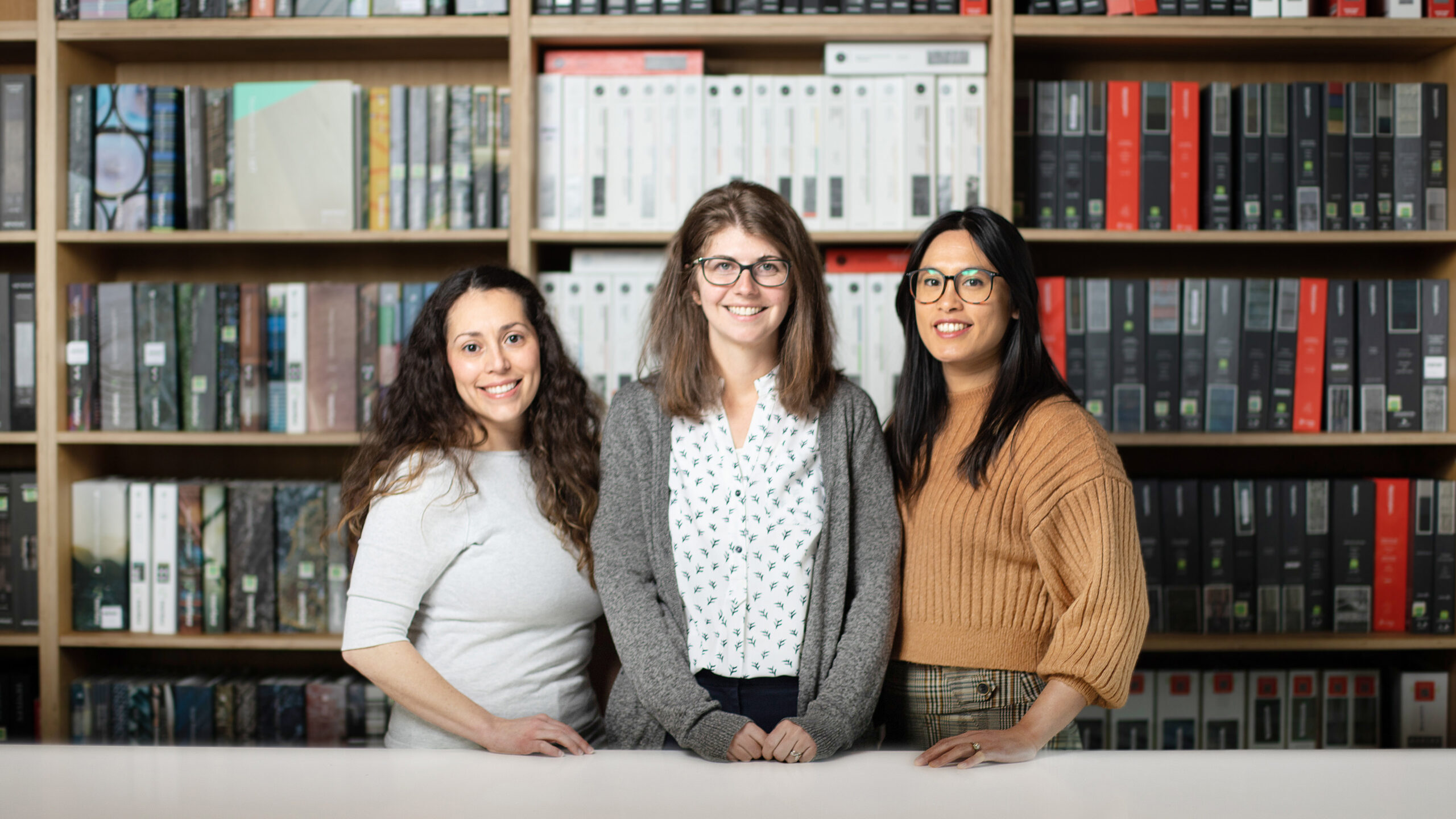 Elisa Zenk, Stephanie Hollar, and Amanda Lunger in the Portland office's design library.