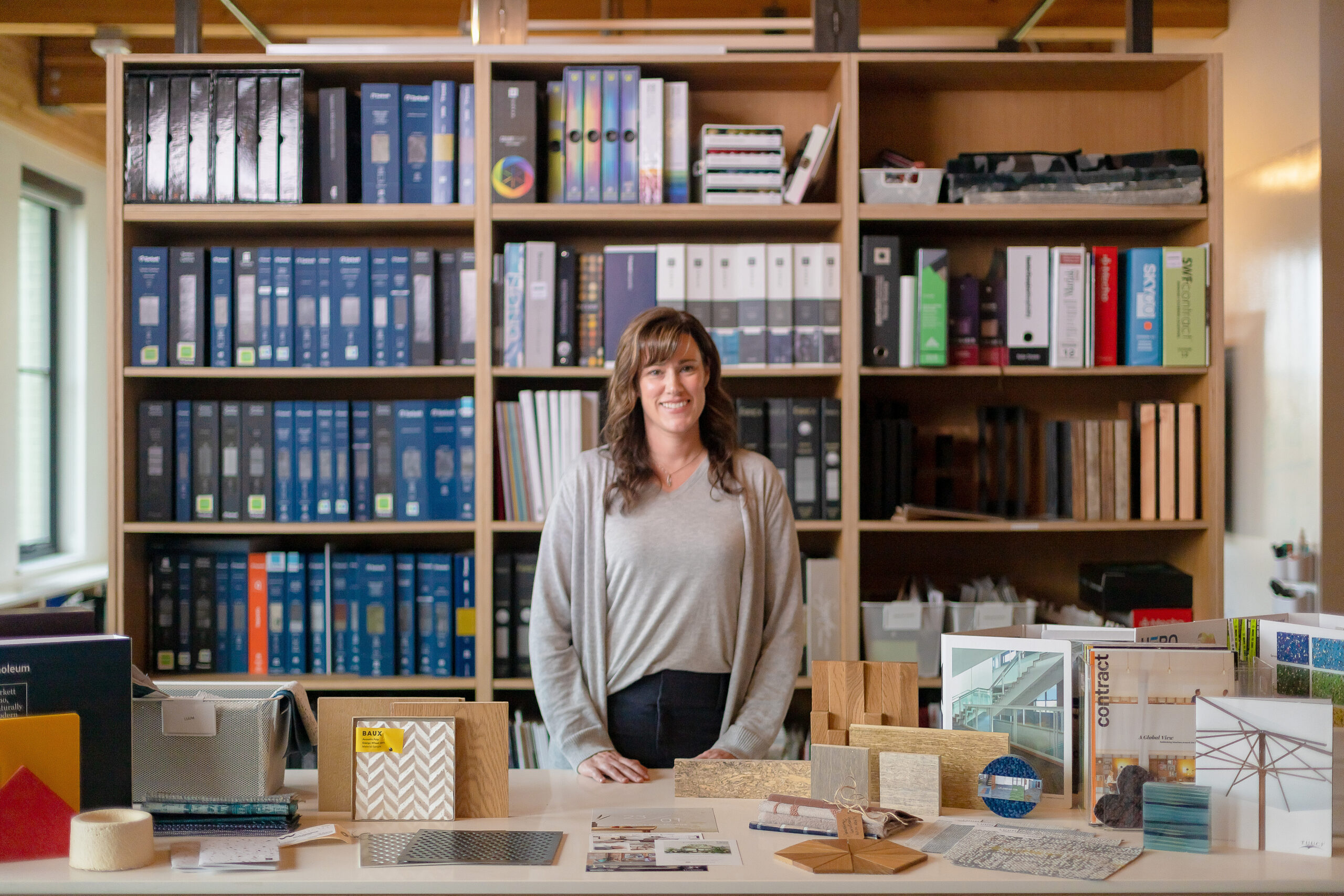 woman stands in materials library smiling at camera